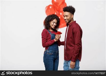 Portrait of young couple in love holding red paper heart and balloon. Portrait of young couple in love holding red paper heart and balloon.