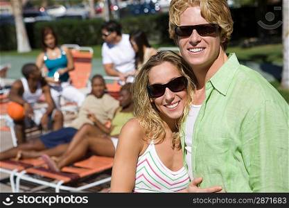 Portrait of Young Couple in Sunglasses, Others in Background