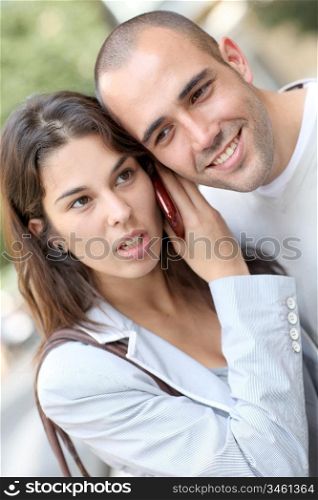 Portrait of young couple in town with smartphone
