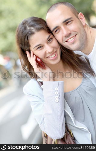 Portrait of young couple in town with smartphone