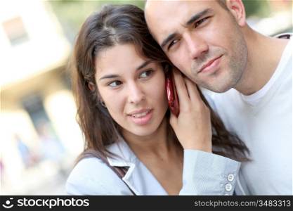 Portrait of young couple in town with smartphone