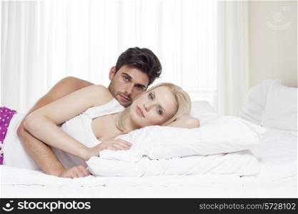 Portrait of young couple lying in bed