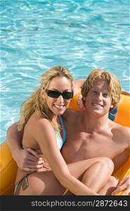 Portrait of Young Couple on Inflatable Raft in Pool