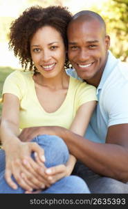 Portrait Of Young Couple Sitting In Park