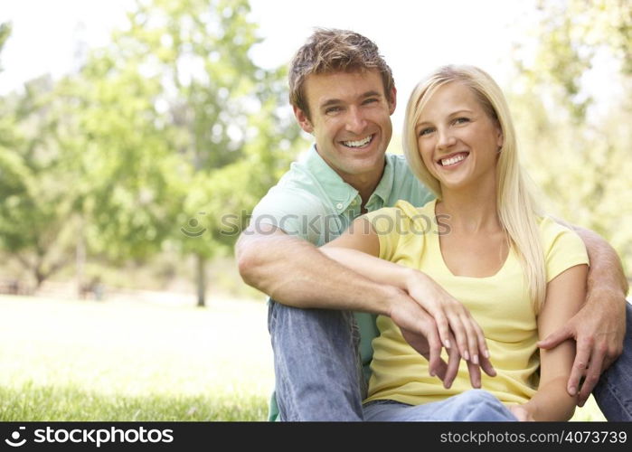 Portrait Of Young Couple Sitting In Park