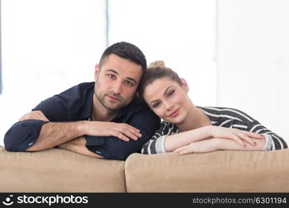 Portrait of young couple sitting on sofa in modern white apartment