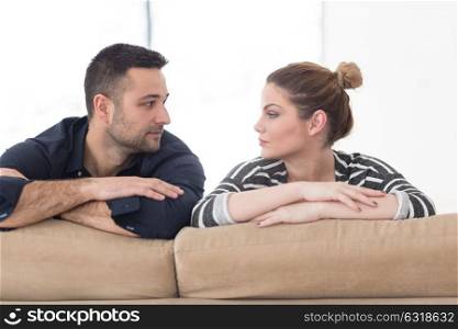 Portrait of young couple sitting on sofa in modern white apartment