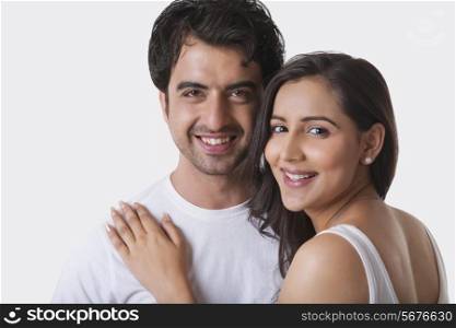 Portrait of young couple smiling against white background