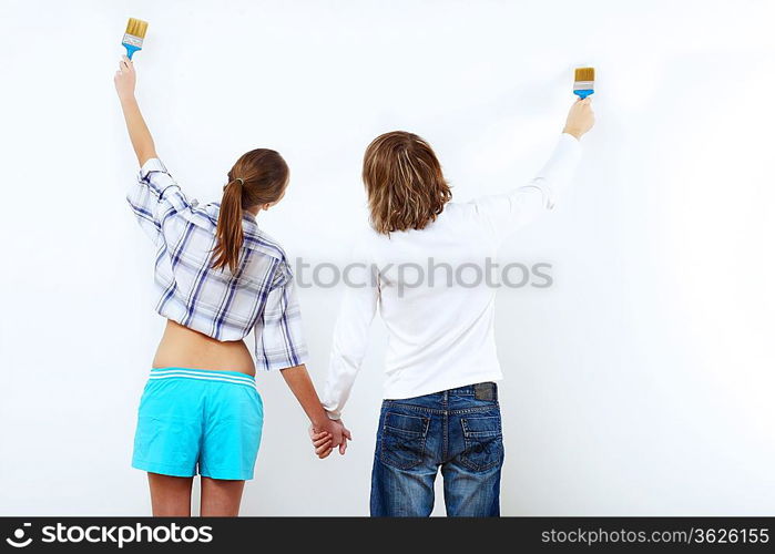 Portrait of young couple with paint brushes