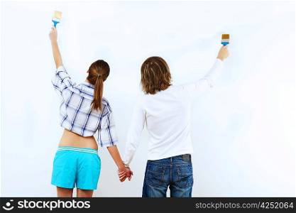 Portrait of young couple with paint brushes