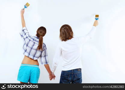 Portrait of young couple with paint brushes