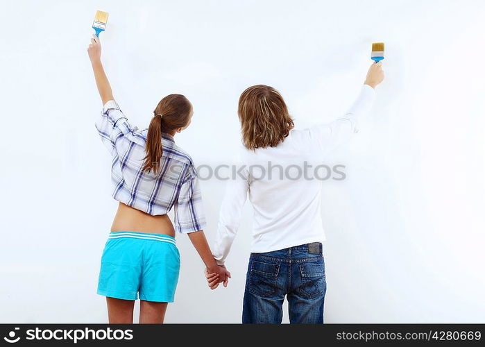 Portrait of young couple with paint brushes