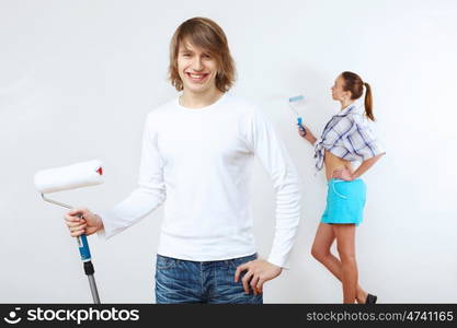 Portrait of young couple with paint brushes