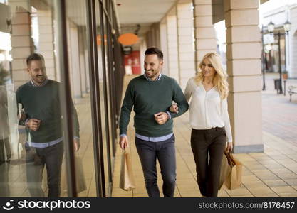 Portrait of young couple with paper shopping bags in city