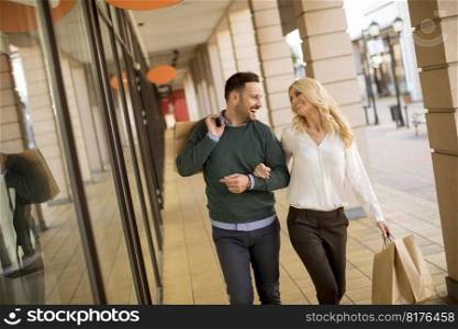Portrait of young couple with paper shopping bags in city