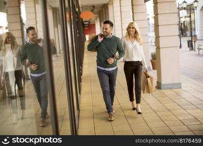 Portrait of young couple with paper shopping bags in city