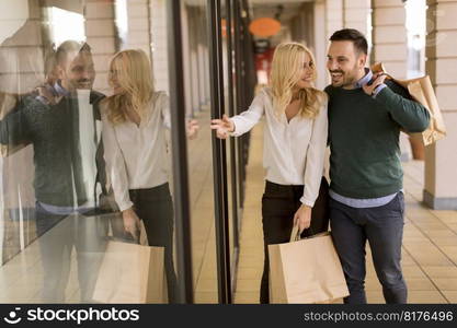 Portrait of young couple with paper shopping bags in city