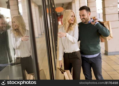 Portrait of young couple with paper shopping bags in city