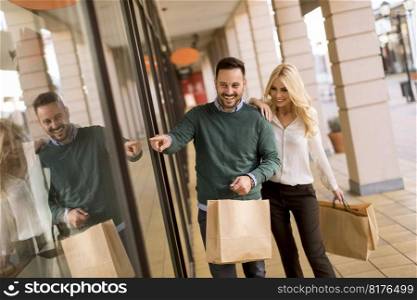 Portrait of young couple with paper shopping bags in city