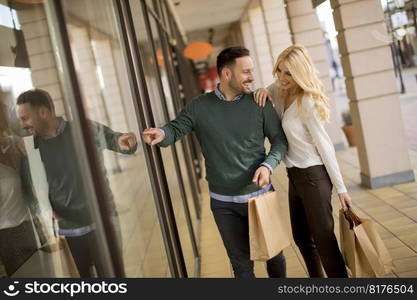 Portrait of young couple with paper shopping bags in city