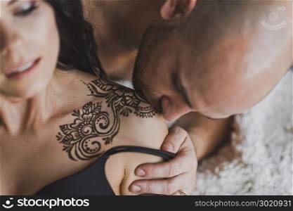 Portrait of young couple with tattoos with henna.. Applied to the shoulders and forearm henna tattoos 196.