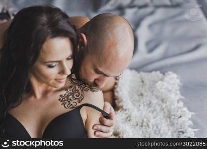 Portrait of young couple with tattoos with henna.. Applied to the shoulders and forearm henna tattoos 195.
