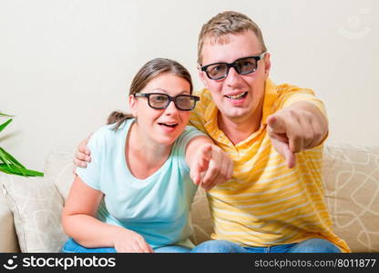 portrait of young couples looking TV in 3D glasses in the living room