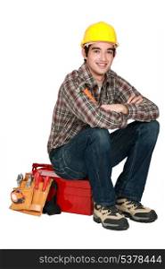portrait of young craftsman sitting on toolcase