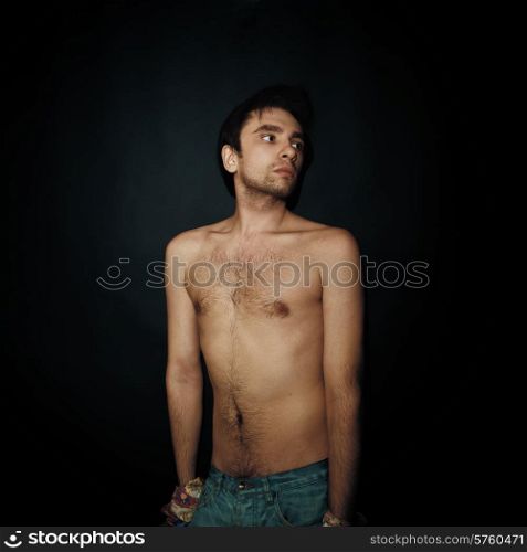 Portrait of young cute nude man on a black background