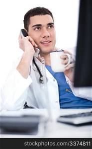 Portrait of young doctor talking over telephone and having coffee in isolated background