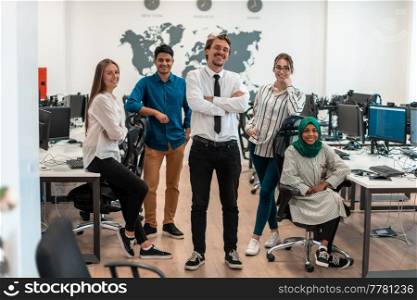 Portrait of young excited multiethnics business team of software developers standing and looking at the camera at modern startup office. High-quality photo. Portrait of young excited multiethnics business team of software developers standing and looking at camera at modern startup office