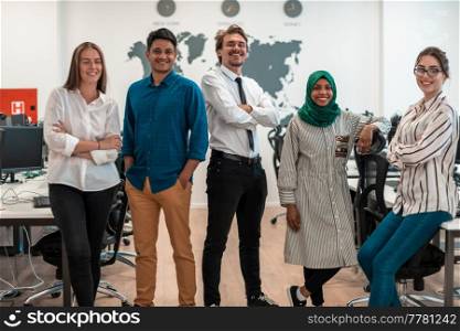 Portrait of young excited multiethnics business team of software developers standing and looking at the camera at modern startup office. High-quality photo. Portrait of young excited multiethnics business team of software developers standing and looking at camera at modern startup office
