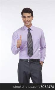 Portrait of young executive giving thumbs up