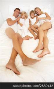 Portrait Of Young Family Relaxing In Bed Together