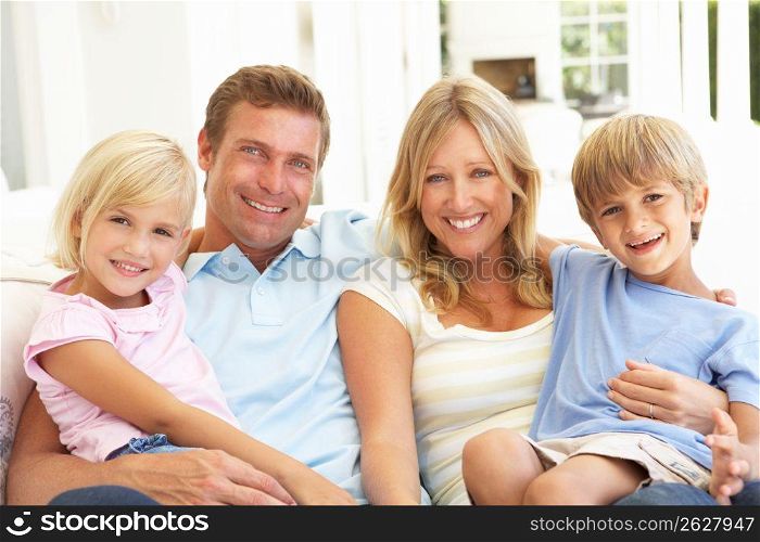 Portrait Of Young Family Relaxing Together On Sofa