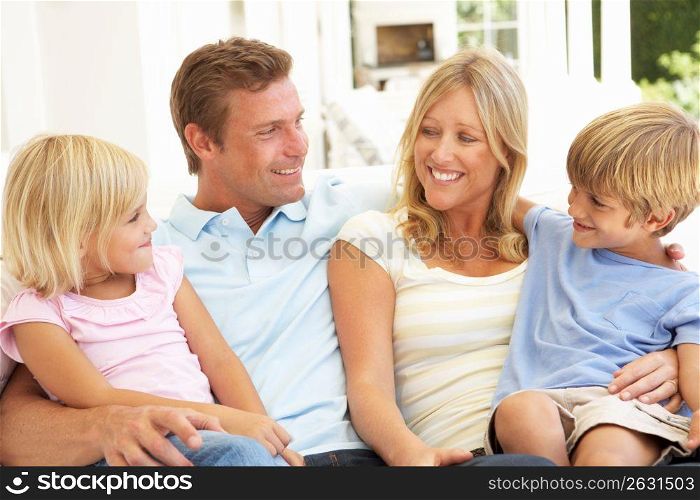 Portrait Of Young Family Relaxing Together On Sofa