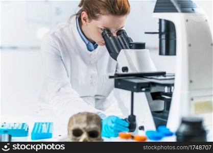 Portrait of young female bioarchaeologist with microscope in a lab.  . Ancient DNA Analysis. Portrait of a Female Archaeologist with Microscope 
