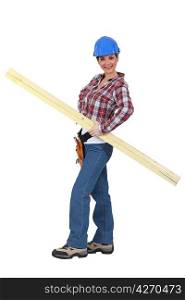 portrait of young female carpenter holding lumber