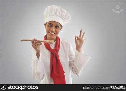 Portrait of young female chef gesturing ok sign