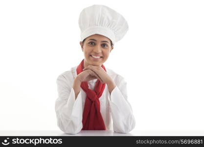 Portrait of young female chef smiling over white background