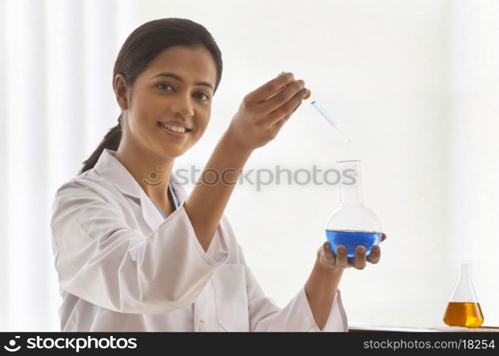 Portrait of young female scientist experimenting in lab