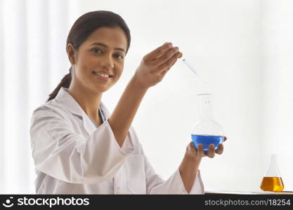 Portrait of young female scientist experimenting in lab