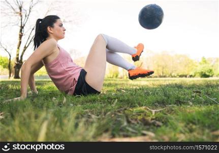 Portrait of young female soccer player training and practicing skills on football field. Sports concept.