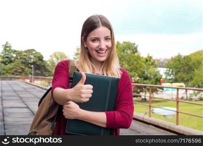 Portrait of young female student with folders and backpack in college campus. Education concept