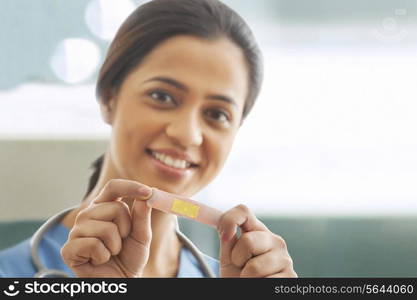 Portrait of young female surgeon holding an adhesive bandage in hospital