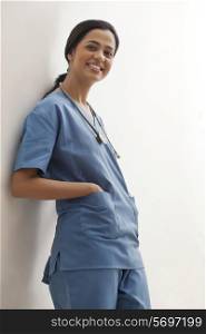 Portrait of young female surgeon with hand in pocket isolated over white background