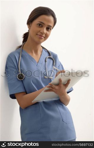 Portrait of young female surgeon writing notes isolated over white background