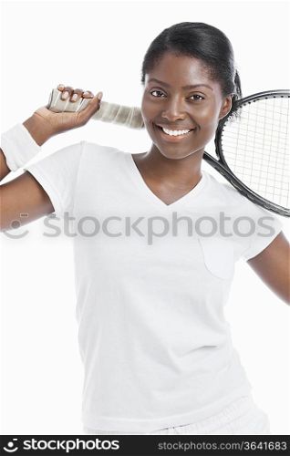Portrait of young female tennis player holding racket over white background