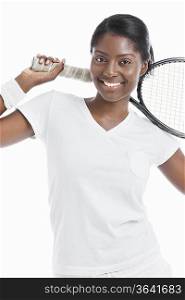 Portrait of young female tennis player holding racket over white background