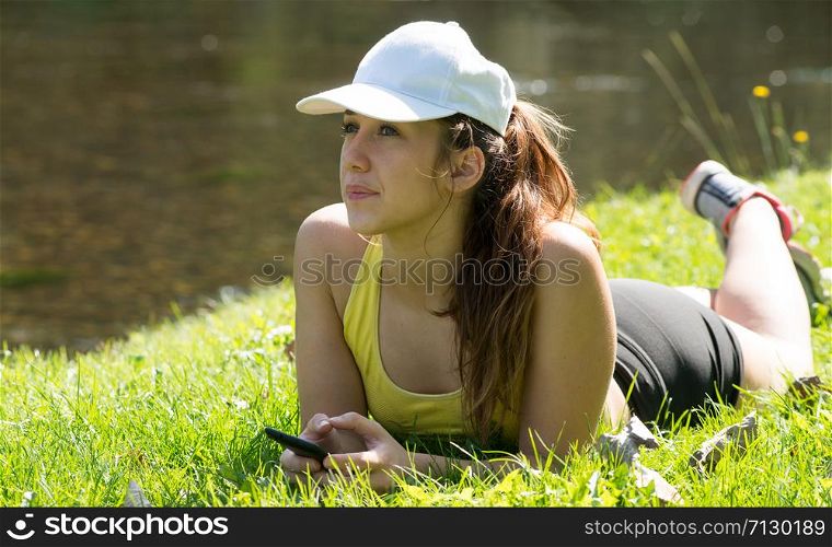portrait of young fitness woman lying on the grass